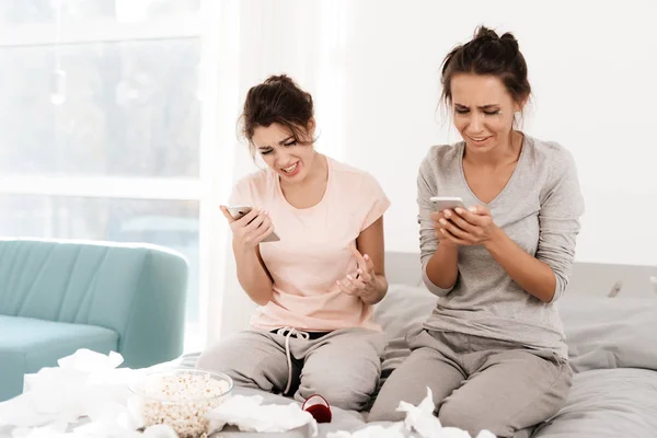 The girls are crying at the hen-party. They are sitting on the bed in a bright room — Stock Photo, Image