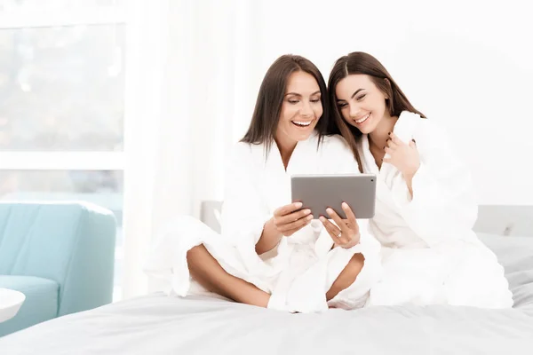 Meisjes hebben een geweldige tijd op het kip-feest. Brunettes in witte badjassen hebben plezier in een lichte kamer. — Stockfoto