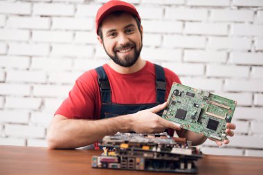 Onun elinde bilgisayardan detayları elektronik cihaz tamir ustası tutar.