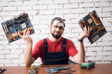 Onun elinde bilgisayardan detayları elektronik cihaz tamir ustası tutar.