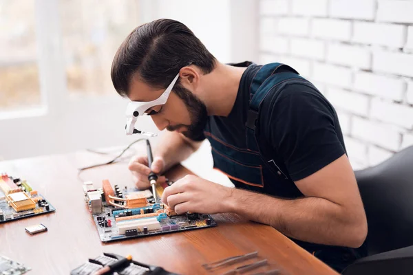 En ung man reparerar en dator. — Stockfoto