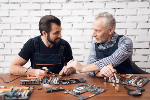 성인과 젊은 남자는 컴퓨터에서 함께 부품을 수리. — 스톡 사진