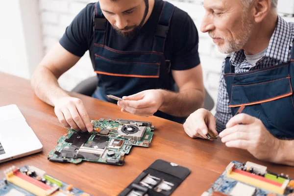 Volwassen en jonge mannen reparatie onderdelen van de computer samen. — Stockfoto