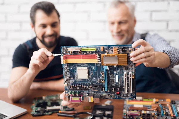 Volwassen en jonge mannen reparatie onderdelen van de computer samen. — Stockfoto