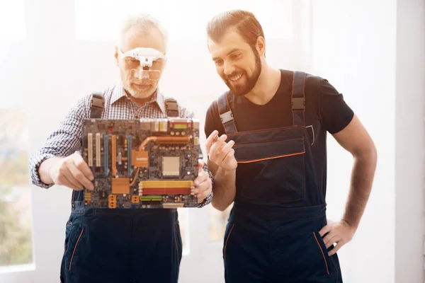 Vuxna och unga män reparera delar från datorn tillsammans. — Stockfoto