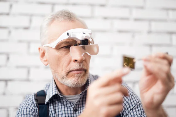 Starší muž vidí procesoru přes speciální brýle. — Stock fotografie