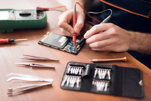 Ein Mann repariert ein Handy. im Rahmen, seine Hände und Details des Gerätes. — Stockfoto