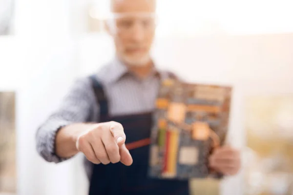 Ein älterer Computerreparaturspezialist posiert für eine Kamera mit einem Motherboard. — Stockfoto