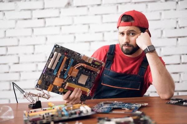 Il maestro della riparazione di apparecchiature elettroniche tiene i dettagli dal computer nelle sue mani . — Foto Stock
