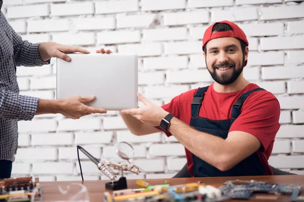 Hlavní opravy elektronických zařízení předává laptop klientovi. — Stock fotografie