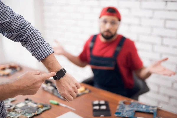 Клієнт показує годинник майстру по ремонту комп'ютерного обладнання . — стокове фото