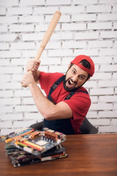 El maestro de la electrónica de reparación supera a un bate de béisbol en las piezas de ordenador . —  Fotos de Stock