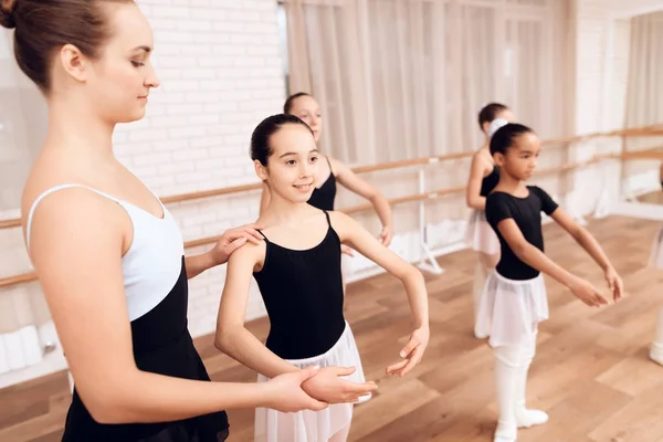 Тренер балетной школы помогает молодым балеринам выполнять различные хореографические упражнения . — стоковое фото