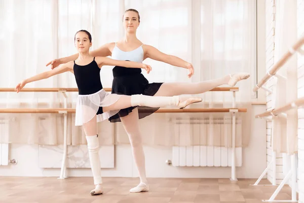 O treinador da escola de balé ajuda jovens bailarinas a realizar diferentes exercícios coreográficos . — Fotografia de Stock