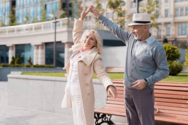 İki emekliler dans tezgah yakınındaki meydanda. Onlar mutlular