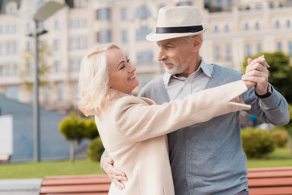 Dos pensionistas bailan en la plaza cerca del banco. Son felices. — Foto de Stock