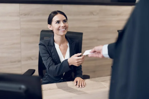Un hombre de negocios con un estricto traje de negocios saluda a la secretaria con su tarjeta de visita. Se sonríen. . —  Fotos de Stock