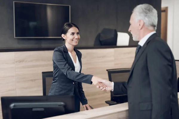 Ein respektabler älterer Herr kam ins Büro. Er traf die Sekretärin. er grüßt sie — Stockfoto