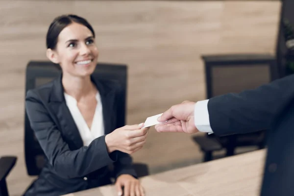 Een zakenman in een strikte pak begroet de secretaris met zijn visitekaartje. Ze lachen naar elkaar. — Stockfoto