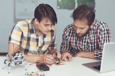 Adam ve adam tahta bir multimetre kullanarak inceleyin. Onlar göstergeleri ölçmek