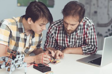 Adam ve adam tahta bir multimetre kullanarak inceleyin. Onlar göstergeleri ölçmek