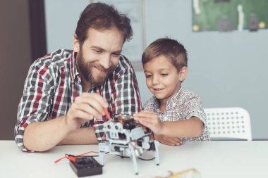 Adam ve küçük çocuk robotun performansını ölçmek. Bir dijital multimetre kullandıkları