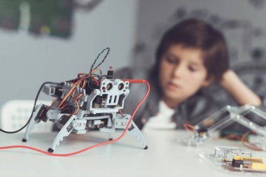 Çocuk bir robot oluşturur. Bir multimetre ile onun veri tedbirleri. Çocuk ölçümleri gözlemler