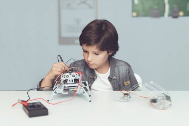 Çocuk bir robot oluşturur. Bir multimetre ile onun veri tedbirleri. Çocuk ölçümleri gözlemler