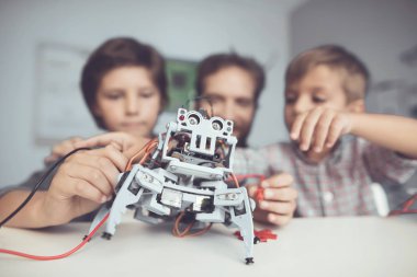 Bir adam ve iki erkek bir robot inşa. Adam çocuklar derleme ile yardımcı olur