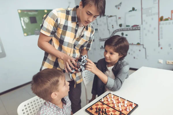 De jonge man bracht twee jongens een grijze robot. Kinderen zijn enthousiast over de robot — Stockfoto