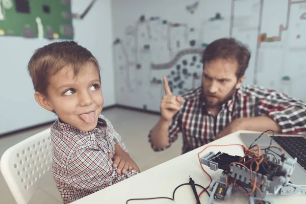 Az ember súlyosan chastises a fiú a elrontja a robot. A fiú elfordult az ember és a croaks — Stock Fotó