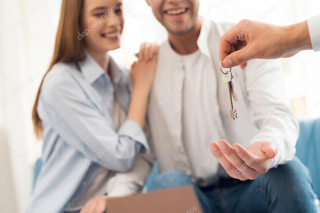 Young couple in a meeting with a realtor. Guy and girl make a contract with realtor buying property.