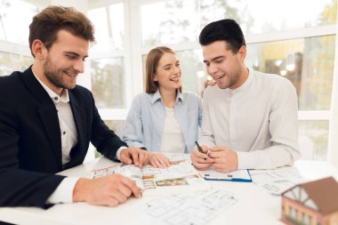 Genç çift bir emlak ile toplantıda. Adam ve kız Emlak Emlakçı ile bir sözleşme yapmak.