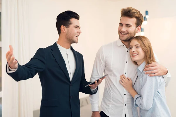 Young couple in a meeting with a realtor. Guy and girl make a contract with realtor buying property. — Stock Photo, Image