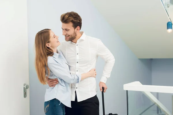 The young couple moved to their own apartment. They stand with suitcases in the entrance. — Stock Photo, Image