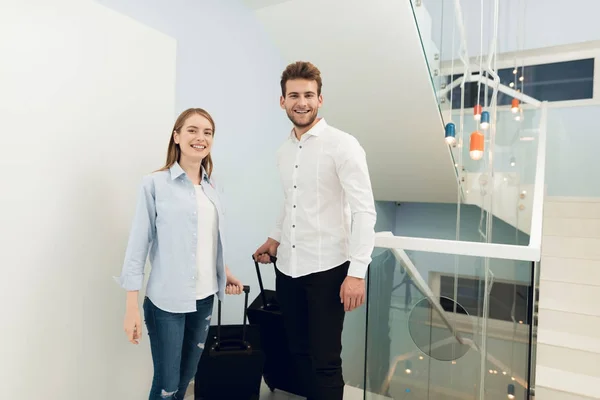 The young couple moved to their own apartment. They stand with suitcases in the entrance. — Stock Photo, Image