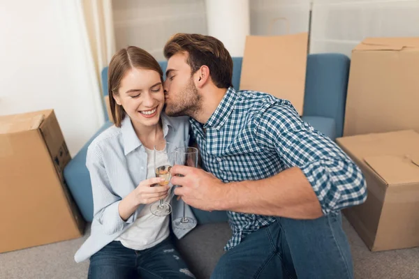 Young couple celebrating with champagne moving to new apartment. Moving newlyweds to new housing. — Stock Photo, Image