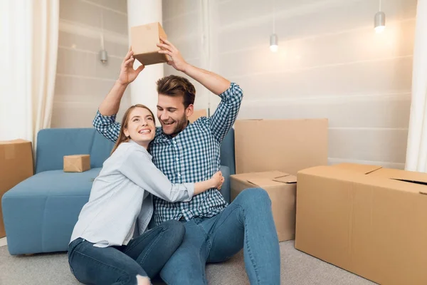 Una pareja joven durante un traslado a un nuevo apartamento. Traslado de recién casados a una nueva vivienda . — Foto de Stock