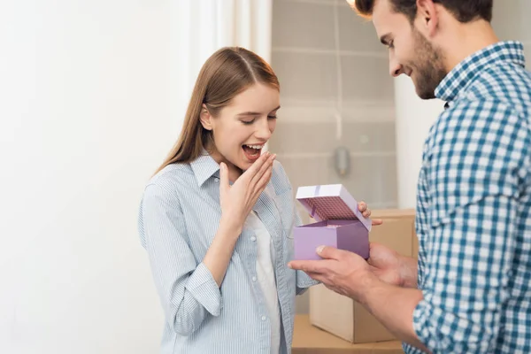 El tipo le da a su novia una caja con un regalo. La chica es muy feliz con los regalos del chico . — Foto de Stock