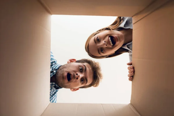 A rapariga e o rapaz estão a olhar para a caixa vazia. Vista de dentro da caixa close-up . — Fotografia de Stock