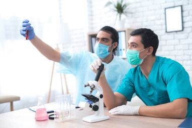 İki doktor tüp bebek sıvı ile seyir.