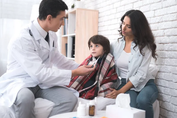 O médico mede a temperatura do menino doente . — Fotografia de Stock