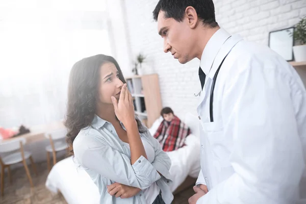 La joven madre habla con el médico que llegó a casa con el niño enfermo . — Foto de Stock