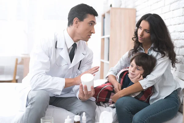 Der Arzt gibt dem kranken Jungen die Tabletten. — Stockfoto