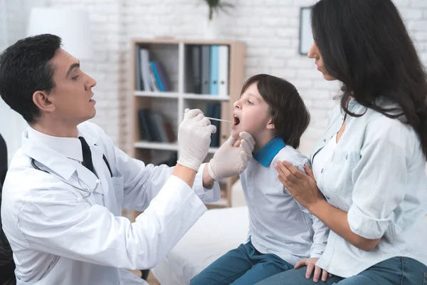 The doctor looks at the boy's throat. — Stock Photo, Image