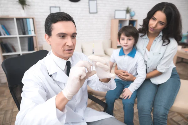 O médico está se preparando para fazer uma picada para o menino doente . — Fotografia de Stock