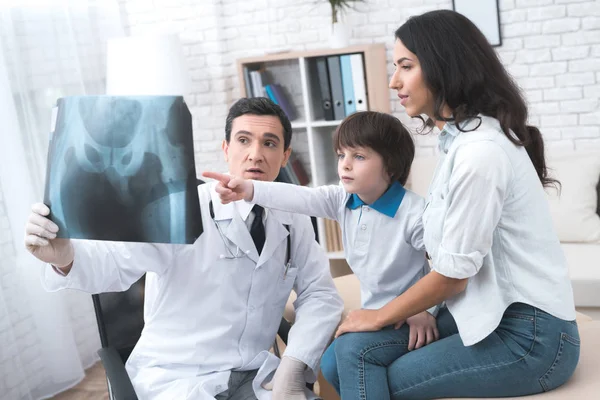 Läkaren visar en röntgenbild av pojken. — Stockfoto