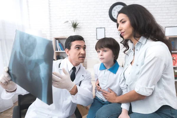 Le docteur montre une radiographie du garçon . — Photo