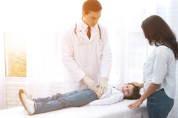 Le médecin en gants blancs masse le ventre d'un garçon malade . — Photo