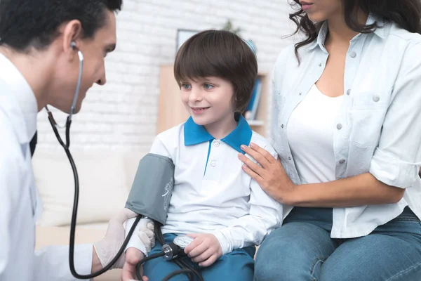 O médico mede a pressão sobre o menino . — Fotografia de Stock